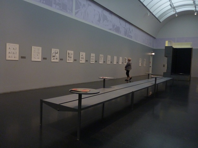 The installation features comics for readers to flip through. At the far end, there's even a bed.