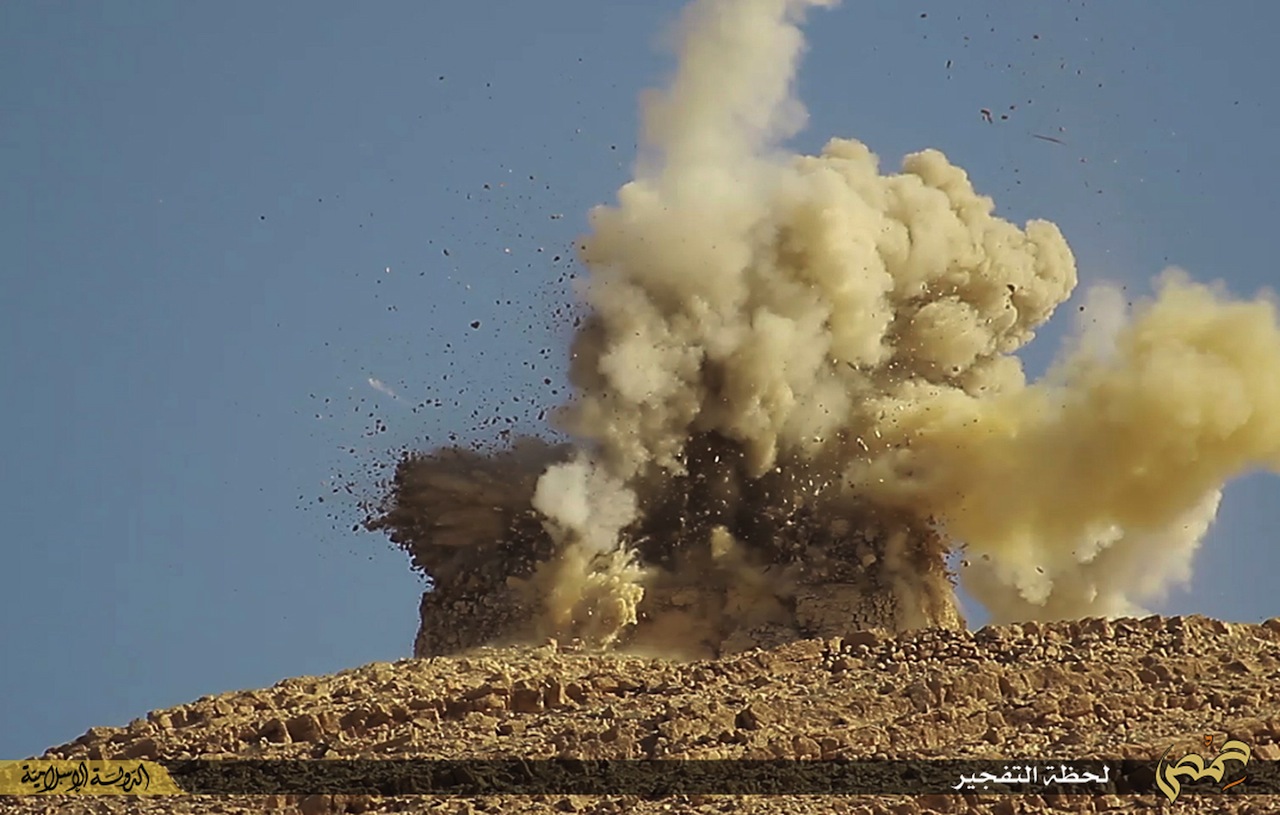 A photo republished by the AP shows ISIS destroying a tomb at the ancient site of Palmyra.