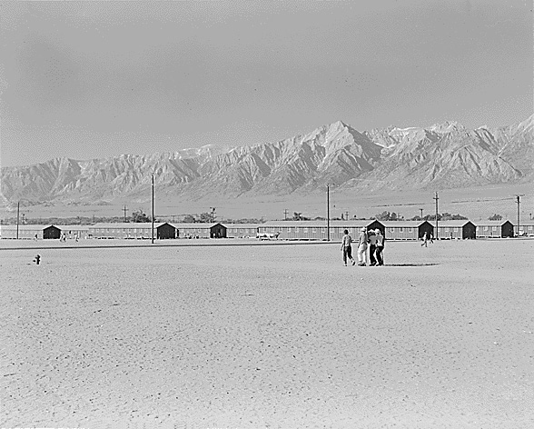 Dorothea Lange, "Manzanar, California, June 29, 1942" (1942), The dry space in the foreground was a playfield that also served as a firebreak between barrack blocks. Mount Williamson overlooks the camp (photographed by Dorothea Lange, WRA, courtesy the National Archives [National Archives Identifier 538122])