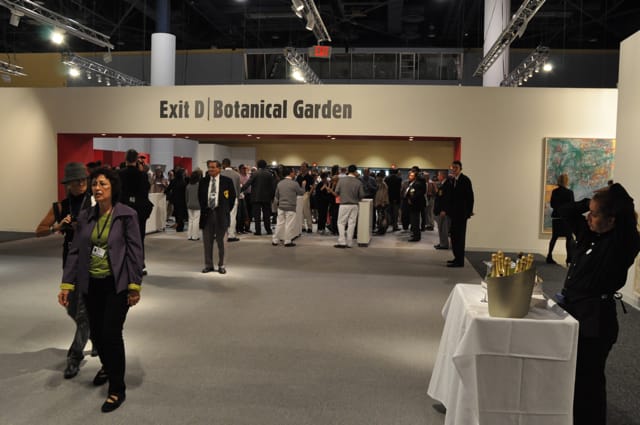 Eager art shoppers await the noon opening of Art Basel Miami and champagne carts (right) await the hunger for $14 glasses of bubbly