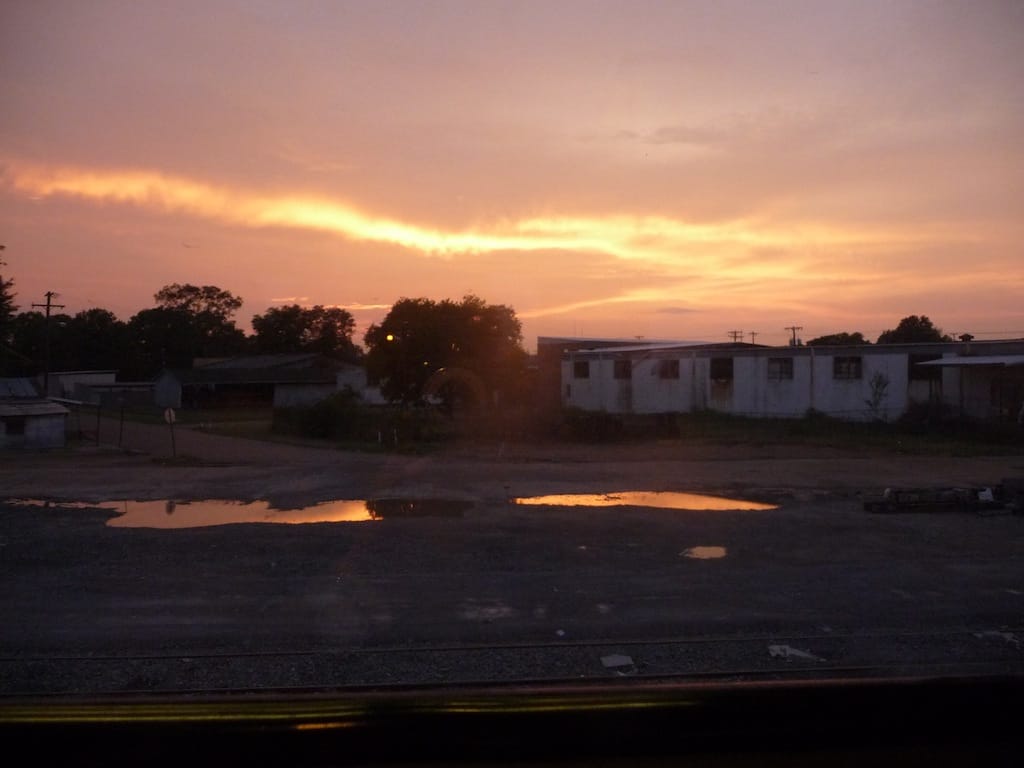 The train brings you through towns you might fly over in a plane and that you wouldn't notice in a car.  Few of these towns cater to tourists and therefore lack the diners and motels familiar to road trippers.  Above is a photo from somewhere in Alabama, as the sun set over our overnighter.