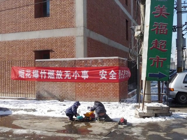 Kids play in the snow outside the red brick gallery complex, host to galleries like Chambers Fine Art, Beijing Art Now, C-SPace and Li Space.