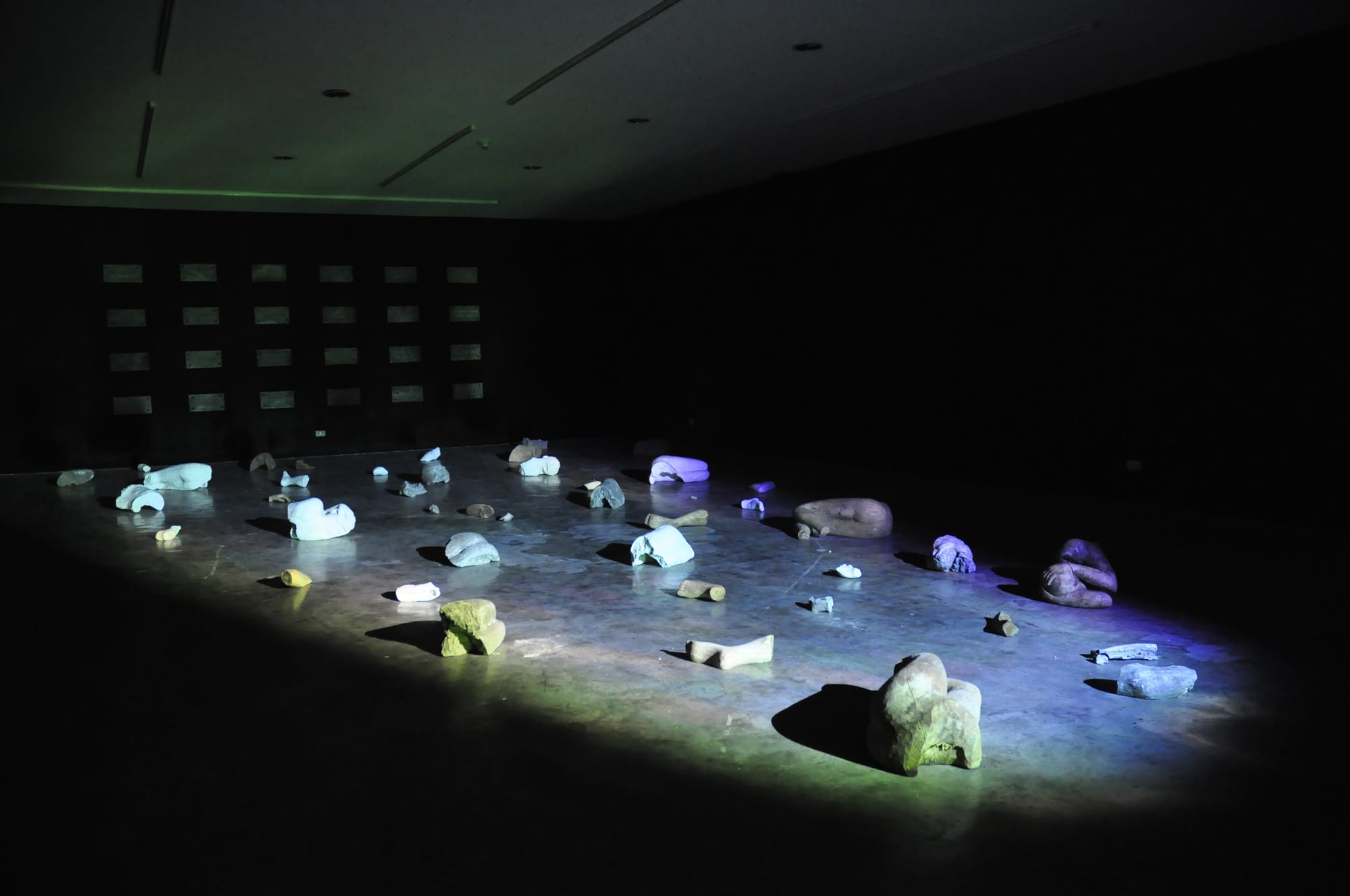 Installation view of the gravestones installed at Mo Space, with her sculpted fragments of a human body.