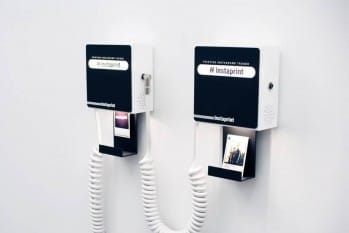 Instaprint installs on a wall and displays the hashtag or geotag you want to automatically print. Image via http://instaprint.me.