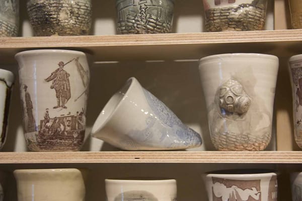 A lopsided cup amid upright ones