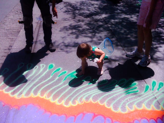 A child enjoys helping Mangrum with his work.