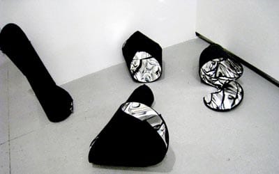 Lots of light bults, odd figures and curved reflective surfaces