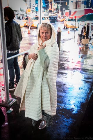 Curator Alana Heiss captured in the slick rain and glowing lights of Times Square on her way to the party. (photo by Ka-Man Tse for @TSqArts)