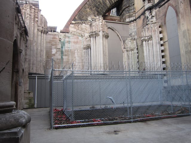 Jane Alexander, "Security" (2006), fiberglass sculpture, oil paint, fence, razor wire, gloves, earth, wheat, machetes, sickles
