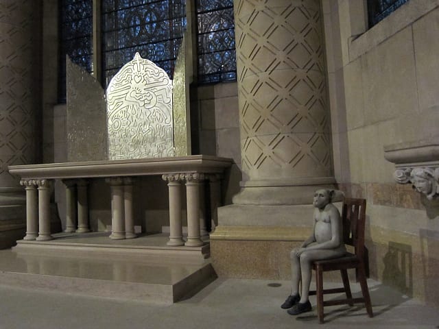 Jane Alexander, "Harvester" (1997-98), plaster, oil paint, wood chair, with St. John the Divine's triptych altar piece by Keith Haring