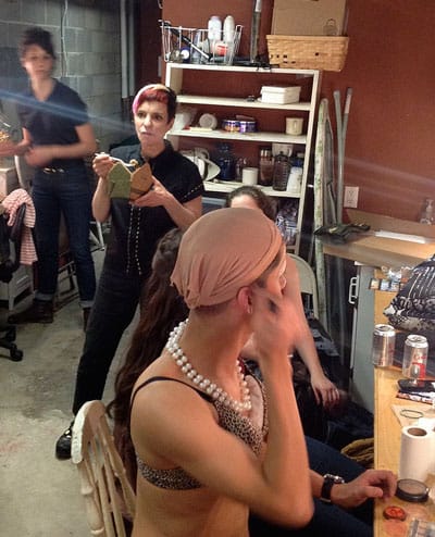 Holly Hughes finishes her dinner backstage at Dixon Place, NYC, while her students prepare to perform her play The Well of Horniness, May 8, 2013. (Source)