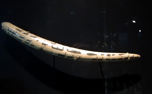 Walrus tusk covered in scrimshaw of Inuit whale hunters, from the 1800s.