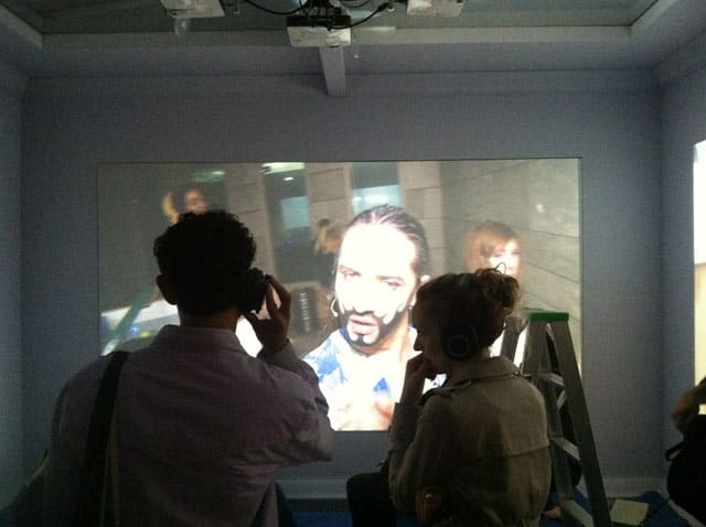 Visitors watching a Ryan Trecartin video inside his installation