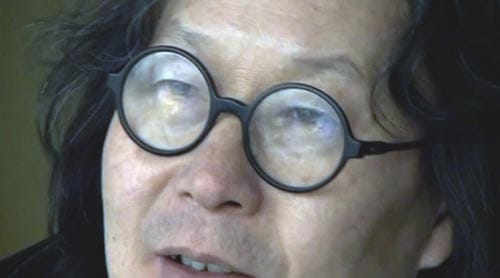 Xu Bing, in his signature "owl" glasses, still from "Phoenix," Itinerant Pictures (c. 2013)