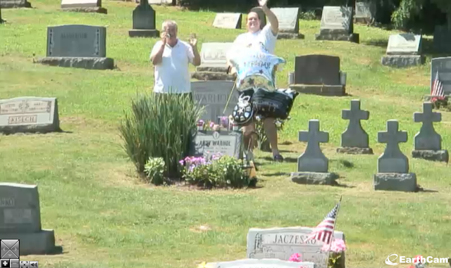 A screen shot from the live feed, of two men visiting Warhol's grave