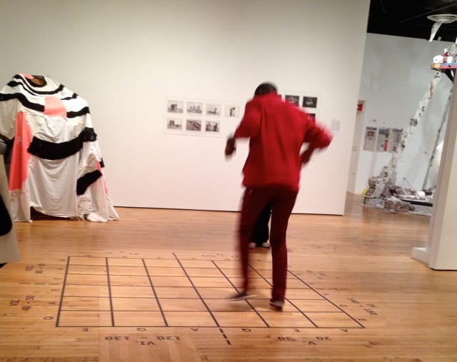 A visitor to the gallery makes up his own game using Benjamin Patterson's Pond (1962), at the Grey Art Gallery's exhibit, Radical Presence: Black Performance in Contemporary Art. (photo by author for Hyperallergic)