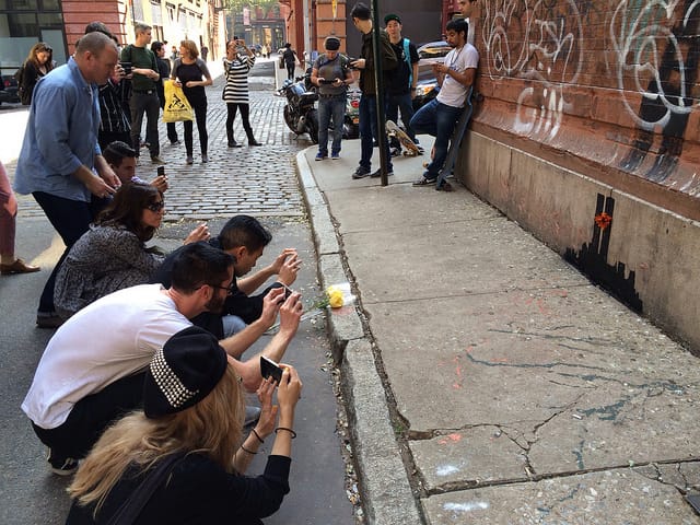 People crouching to take photos look like people in prayer.