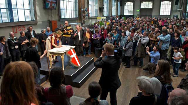 A woman dressed up as the Swiss Helvetia signs the basic-income popular initiative (via Facebook).