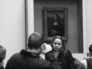A woman poses for a portrait with the Mona Lisa (photo by Carrie Cizauskas, via Flickr)