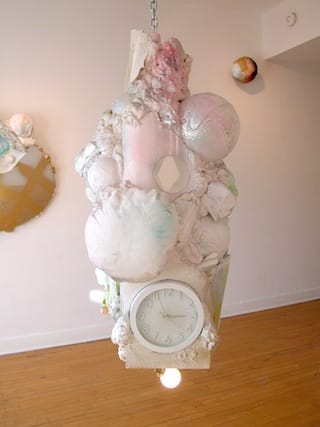 Sabina Ott, “why is a pale white not paler than blue,” (2012), polystyrene, canvas, burlap, acrylic, spray enamel, mirror, clock, spray foam, light fixture, metal chain, 100″ x 24″ x 24″ (courtesy Riverside Arts Center) (click to enlarge)