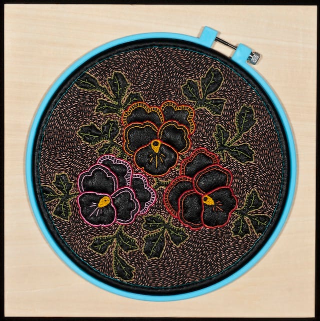 John Thomas Paradiso, "Leather Pansy II," (2010). Leather, thread, and plastic hoop on wood panel  10 x 10 x 1.5 in. Courtesy of Elisabeth Jacobsen. Photo credit: John Thomas Paradiso.