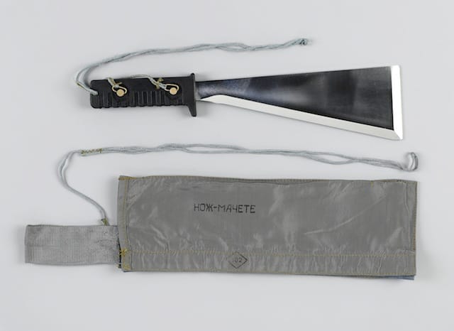 COSMONAUT SURVIVAL MACHETE.  Large 14 inch machete consisting of a long 9 inch triangular blade having a sharpened fore-edge and head with a 4 ½ removable black rubber handle.  Est. $500-700  