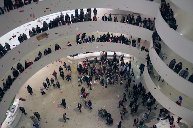 Dollar bill leaflets rain down Guggenheim rotunda at 6:45 pm (all photographs by the author for Hyperallergic)