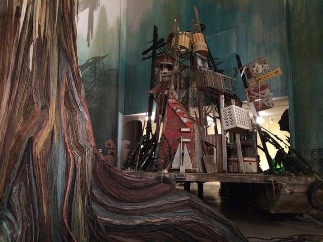 A view of the tree trunk and one of the two boats.