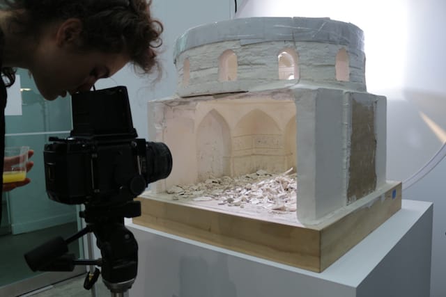 A guest inspects Bilal's model through a medium-format camera at pre-opening event. (click to enlarge)