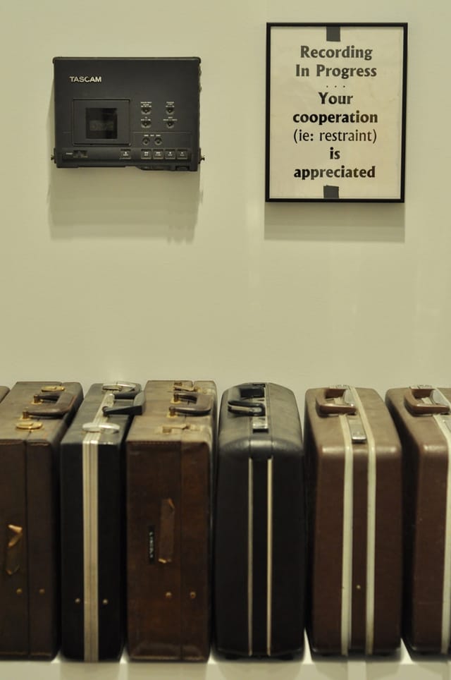 Malachi Rischer’s portable digital audio tape (DAT) recorder, sign used while making concert recordings, and eight briefcases (photo by Hrag Vartanian for Hyperallergic) (click to enlarge)
