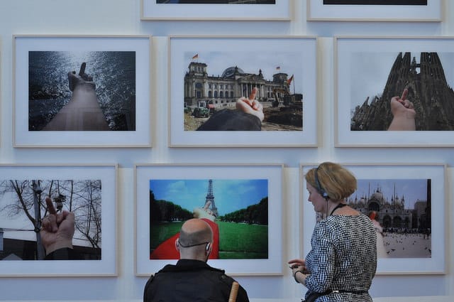 Museum visitors in front of some of the images in Ai Weiwei's "Study of Perspective" (1995-2011) series, 40 photographs