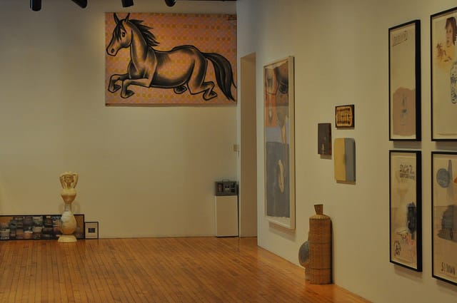 Ruby Neri's "Untitled" (c.1992), spraypaint on fabric, hangs high above one corner of the show. Another ceramic piece on the floor, also by Neri,  is closeby.