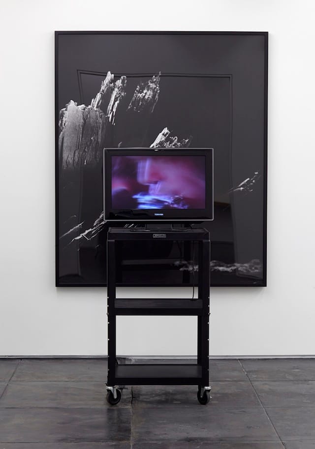 Scott Benzel, "Magnified / Erased" (2014), electron microscope photograph of a flake of cocaine from the book 'Magnifications,' video of rotoscopic erasure of a flake of cocaine from Neil Young's nostril from the film 'The Last Waltz,' flatscreen, media cart (click to enlarge)