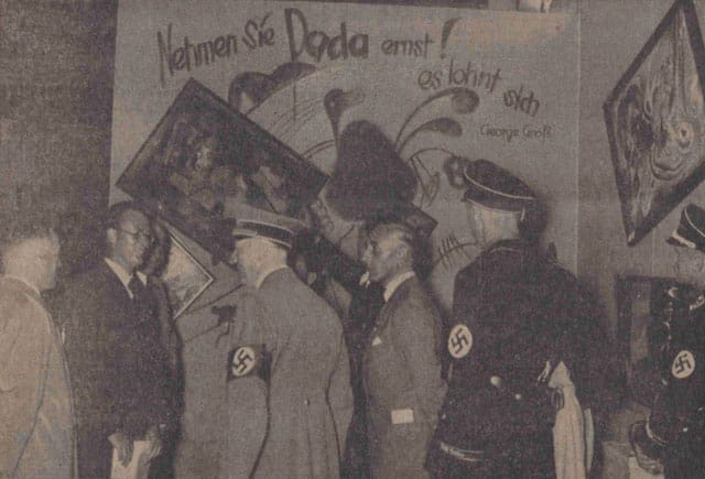 Adolf Hitler and other Nazi officials (Hoffmann, Willrich, Hansen, and Ziegler) standing by the Dada wall at the 'Entartete Kunst' (Degenerate Art) exhibition, July 16, 1937. Paintings by Vasily Kandinsky, Paul Klee, and Kurt Schwitters have been deliberately hung askew and are accompanied by a slogan penned by George Grosz. This photo was published in the Nationalist Observer, South German (Süddeutsche) issue, No. 199, July 18, 1937. (Staatsbibliothek zu Berlin Stiftung Preussischer Kulturbesitz, Berlin, Germany; bpk, Berlin, Art Resource, NY)