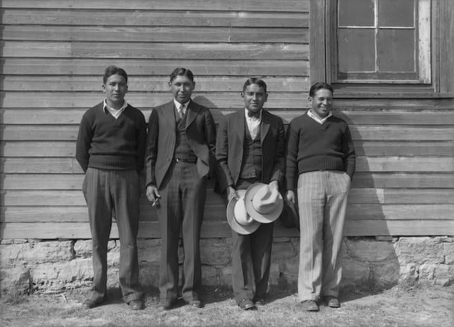 Caption: The deacons of Rainy Mountain Baptist Church. Left to right: Adolphus Goombi (Kiowa), Lester Momaday (Kiowa), Robert Goombi (Kiowa), Porter Drywater (Cherokee). Rainy Mountain Church, Mountain View, Oklahoma, ca. 1930. 57PN12