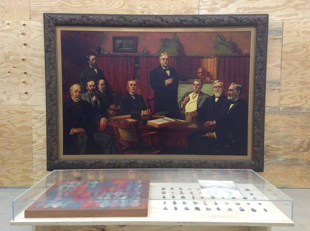 Installation view, 'Another Look at Detroit' at Marlborough Chelsea, with Percy Ives's "First Board of Trustees of Detroit Museum of Art" (1907) hanging behind Wallace MacMahon Mitchell's "Painting with Ovals" (1950) and 50 pieces of Fordite cabochons in display case