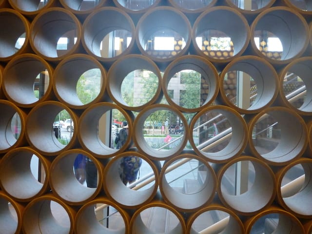 Ban's famous paper tubes gird the inside of the museum, adding texture to the view from both sides.