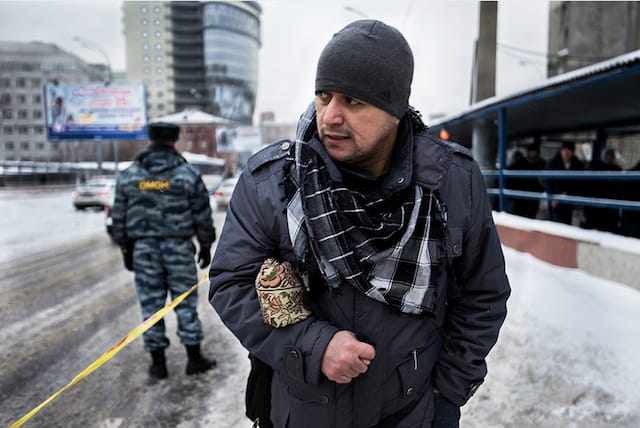 A labor migrant in Moscow after Friday prayer, run under the supervision of the police.