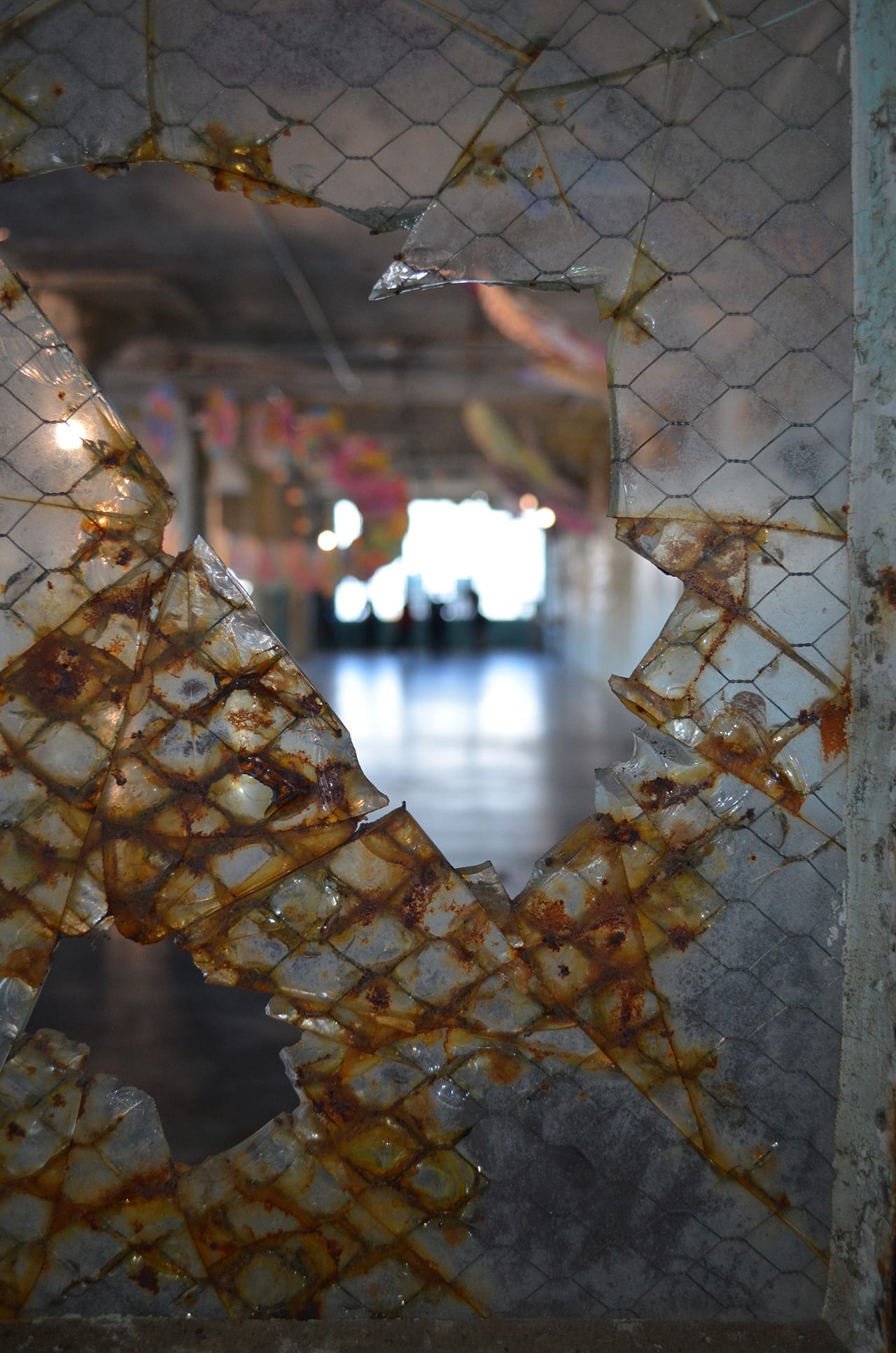 One of the broken windows of Alcatraz with the paper dragon in the background.