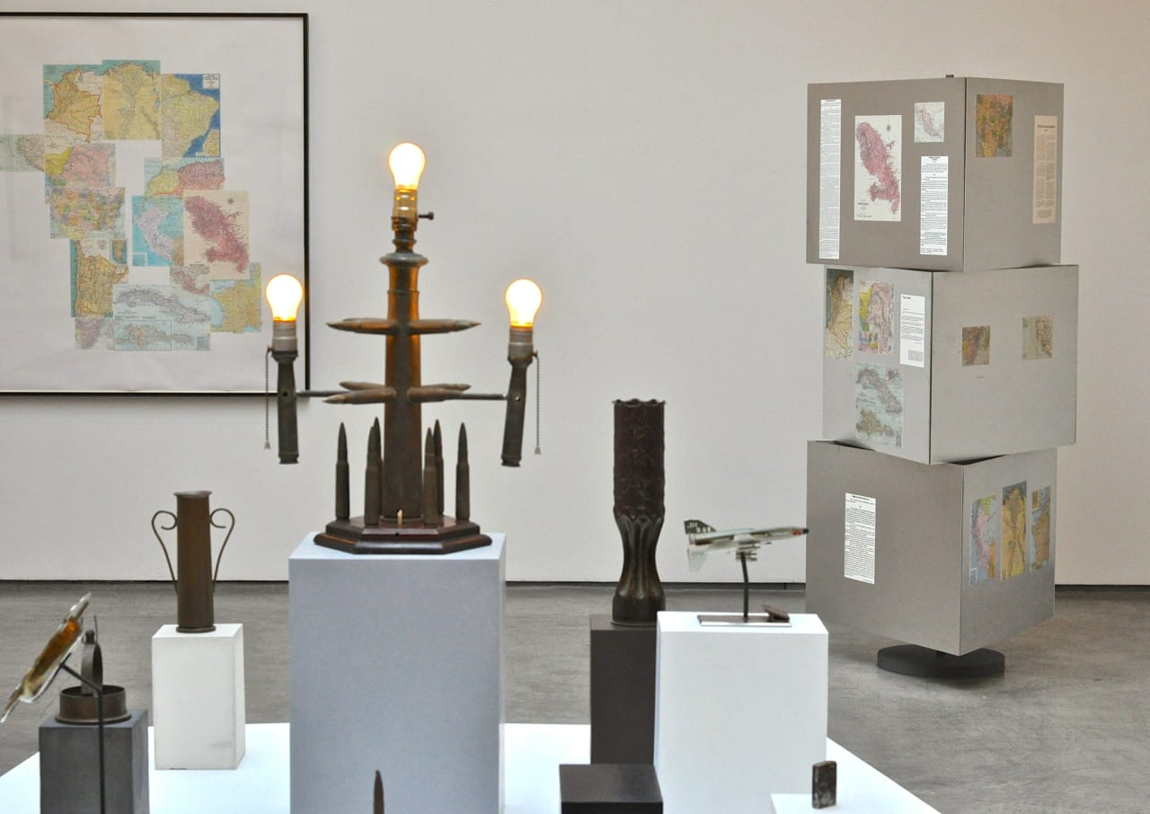 Sam Durant, “An Ingression of the Superstructure Into the Base” (2014), found objects, light bulbs, plaster, wood, marble, steel, wood, MDF, acrylic, gauche, (fabrication Chris Dyson) overall 65.5 x 56.5 x 57 in. (166.4 x 143.5 x 144.8 cm), in the foreground.