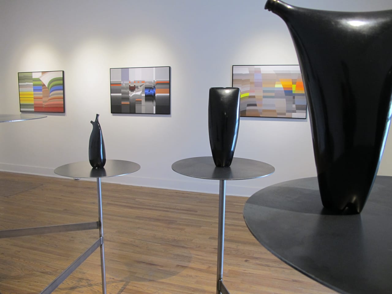 Central Features, with Jami Porter Lara's ceramic "bottles" in the foreground and Patronio Bendito's digital prints along the back wall (all images courtesy Central Features)