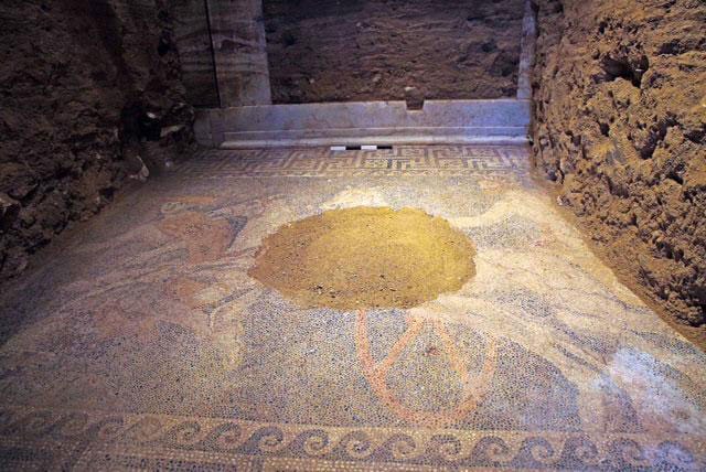 A view of the second chamber mosaic floor and the door to the third chamber at the back