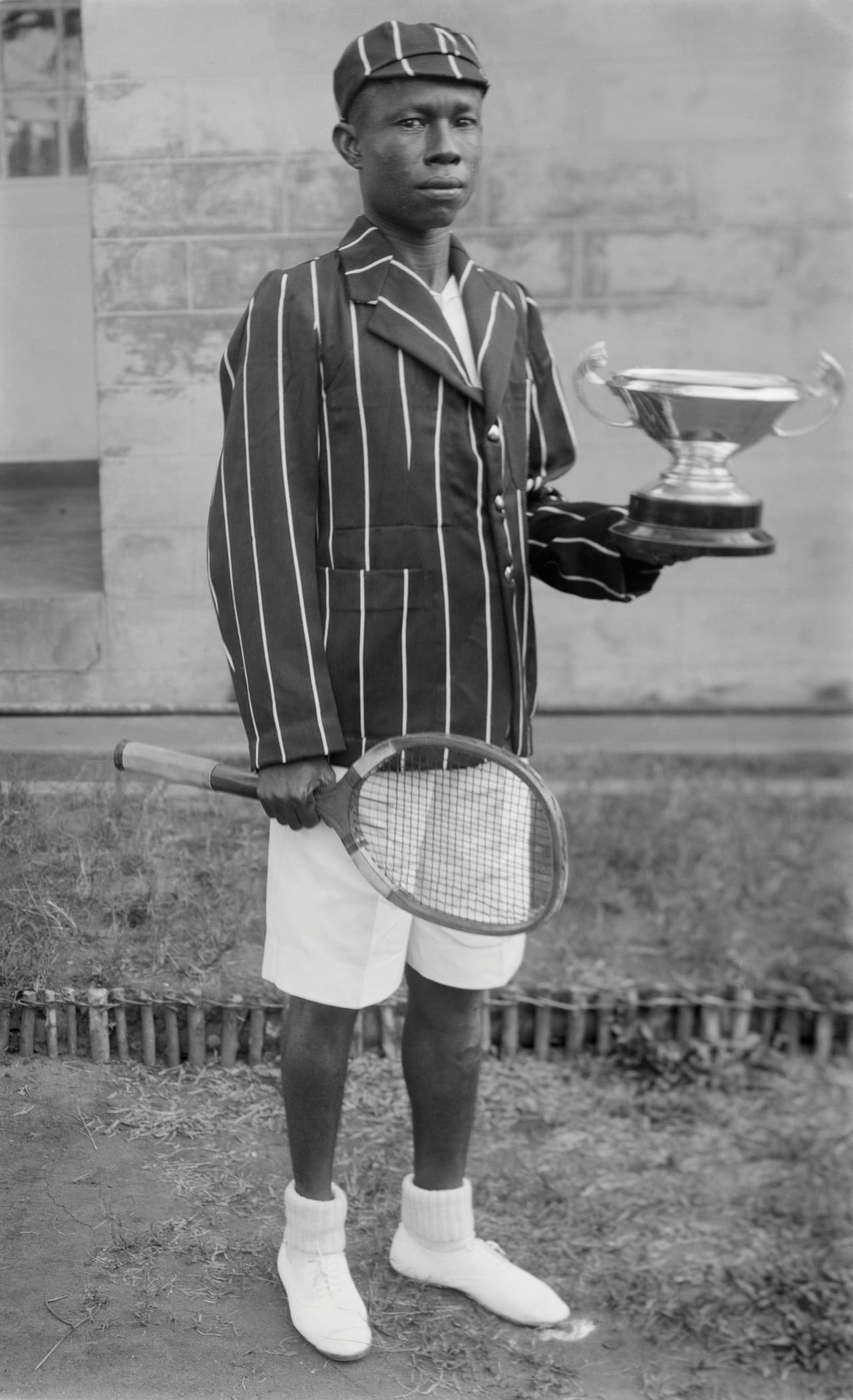 Boy with tennis racquet and trophy, Chief S.O. Alonge: Photographer to the Royal Court of Benin, Nigeria