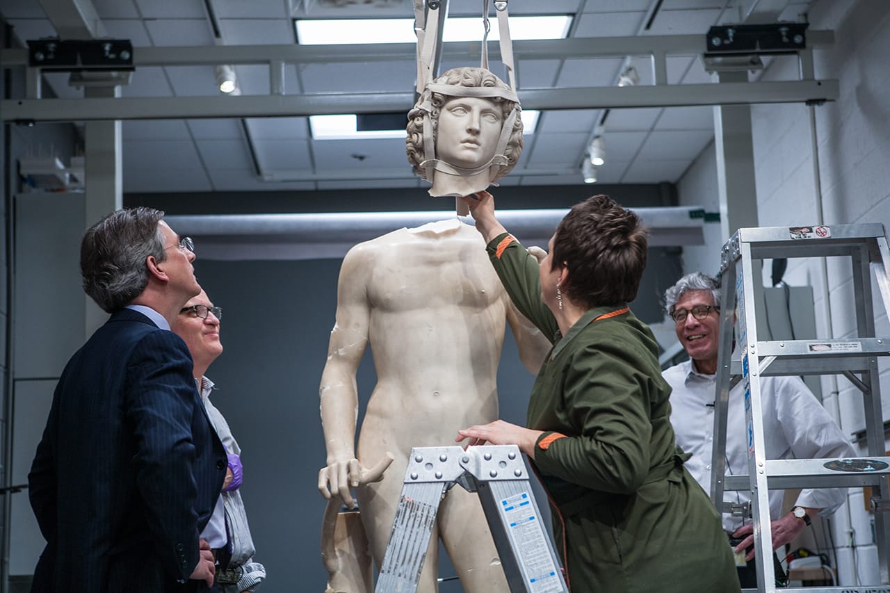 Conservators prepare to reattach Adam's head.