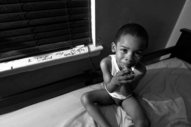 Nijel plays  on his bed. 