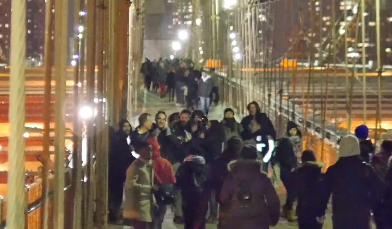 Two NYPD officers skirmish with a group, allegedly including Eric Linsker, on the Brooklyn Bridge on December 13 (screenshot of YouTube video)