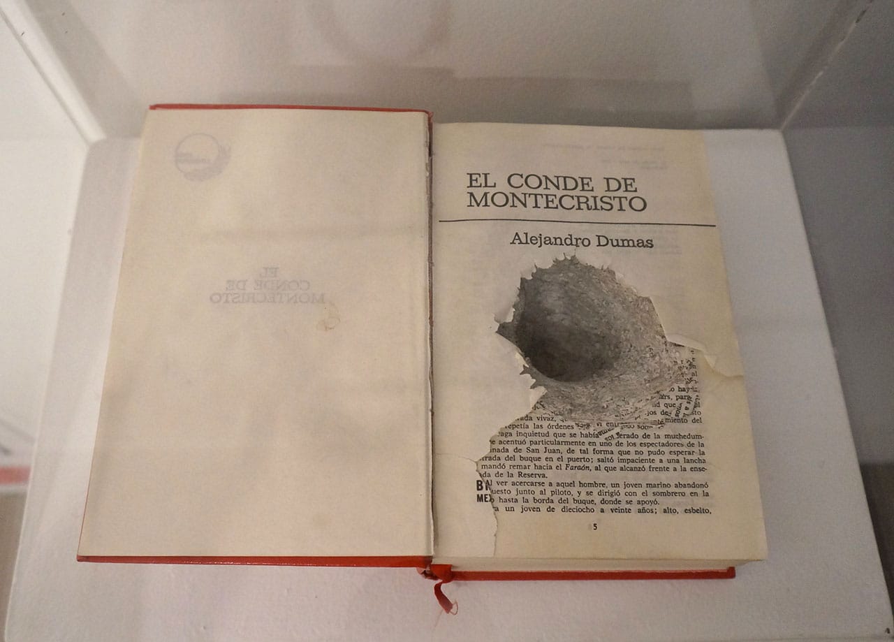 José Antonio Vega Macotela, "Time Divisa. Intercambio 291" (2009), intervened book. "In exchange for the time the artist spent searching his girlfriend based on the memories he had of her, 'El kamala' used the nervous tick in his right hand to scratch a hole through the center of the novel the Count of Monte Cristo."