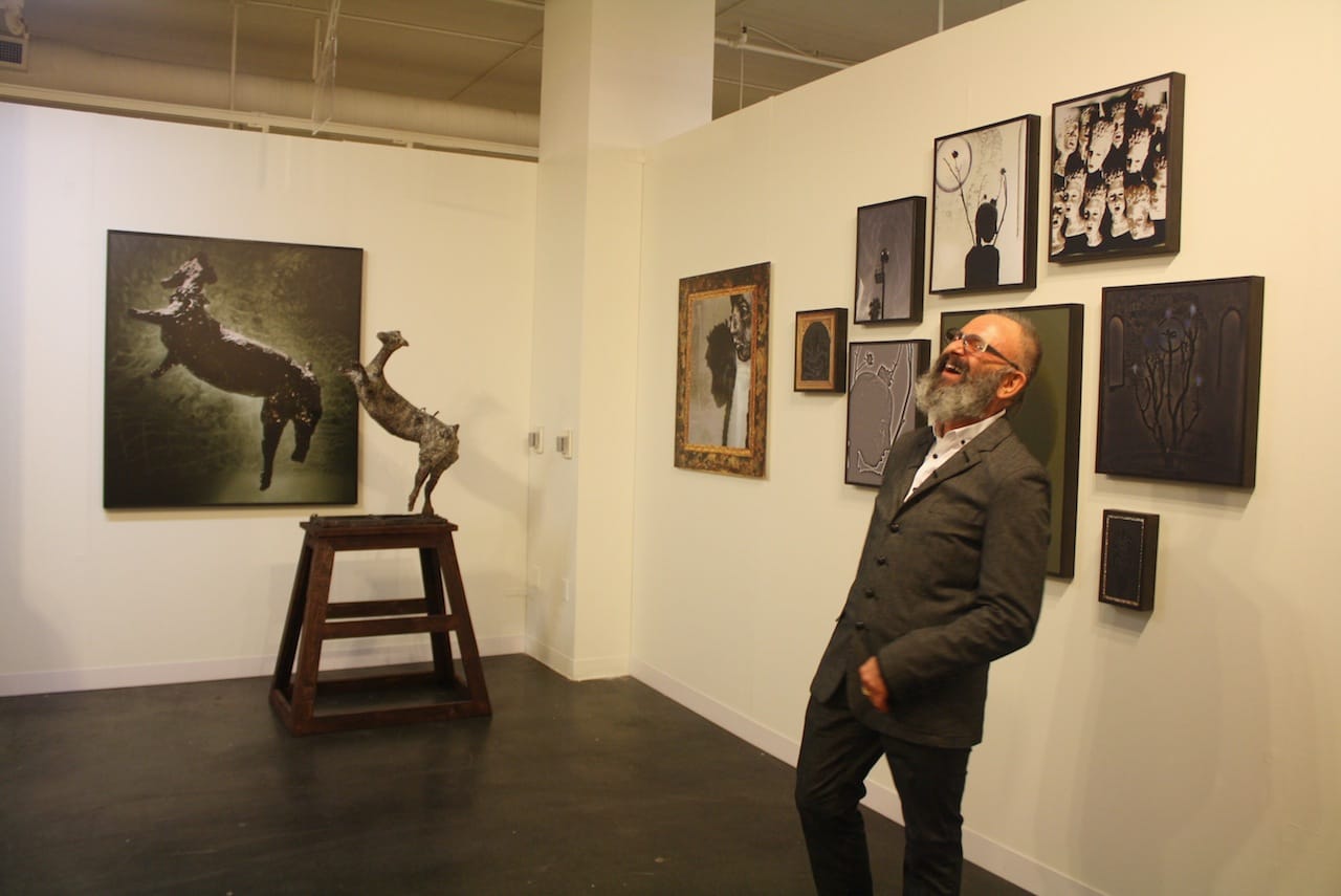 Simon Toparovsky, caught mid-laugh in front of his work.
