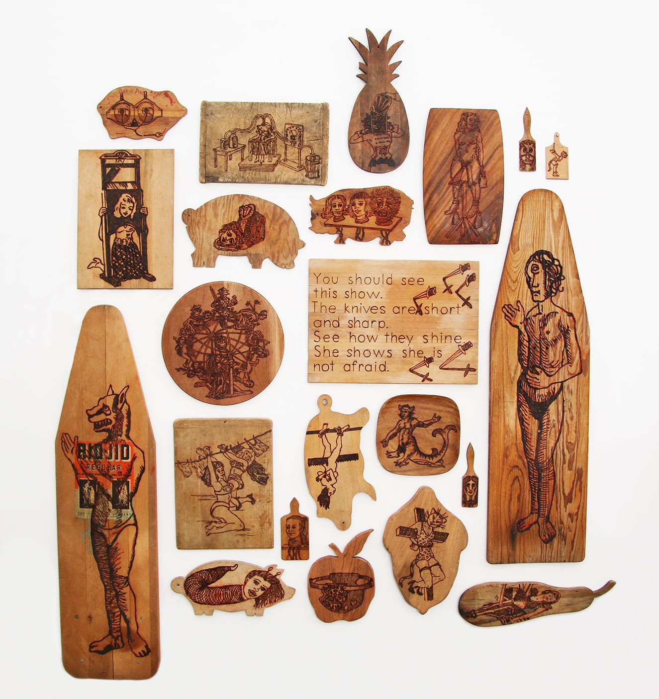 Pamela Joseph, Selected works from The Hundred Headless Women Cutting Board Wall, 2001–2013, pyrog- raphy on wood, 91 x 96 in., Courtesy of the artist. Photo: Pamela Joseph