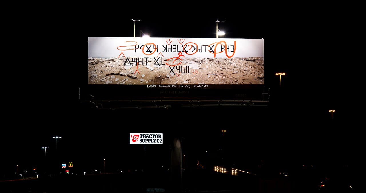 Billboard #1 at night above interstate highway (Image courtesy of the artist)